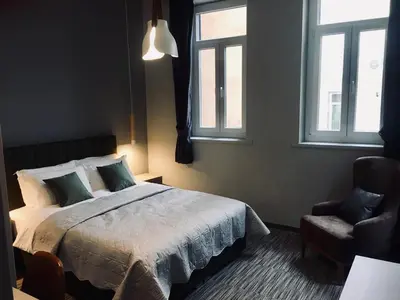 a bedroom with a bed and a chair and windows at Metis Athens Suites in Athens
