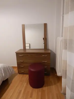 a bedroom with a dresser with a mirror and a stool at ATHENS RIVIERA SEA VIEW APARTMENT in Piraeus