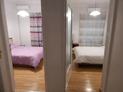 a room with two beds and a mirror at ATHENS RIVIERA SEA VIEW APARTMENT in Piraeus