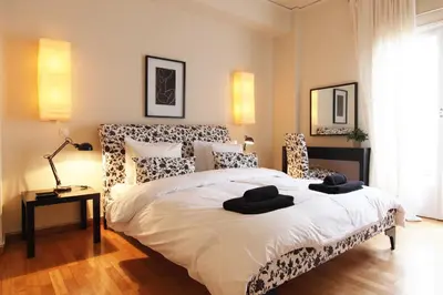 a bedroom with a large bed with black and white furniture at Dream Penthouse in Athens - Kolonaki in Athens
