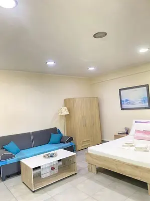 a living room with a couch and a bed at Cozy apartment near to the airport in Kouvarás