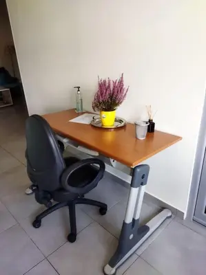 a desk with a chair and a table with flowers on it at Cozy apartment near to the airport in Kouvarás