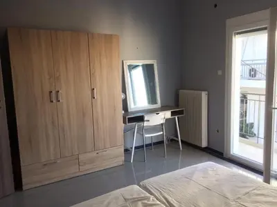 a bedroom with a desk and a cabinet with a mirror at Joges 2 in Athens