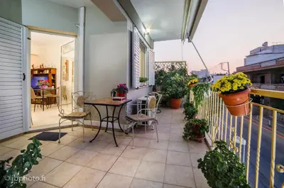 a patio with a table and chairs on a balcony at Mary's House Apartment 10 min from Athens Airport in Markopoulo