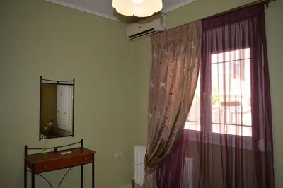 a room with a window and a dresser and a mirror at Mary's House Apartment 10 min from Athens Airport in Markopoulo