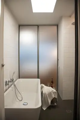 a bathroom with a white tub and a shower at Majestic City Hall in Athens