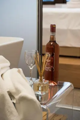 a bottle of alcohol and a wine glass on a table at Majestic City Hall in Athens