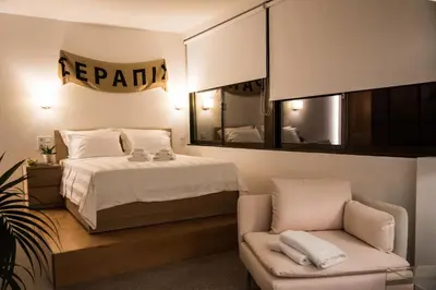 a bedroom with a bed and a chair and a mirror at Majestic City Hall in Athens