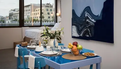 a blue table with a bowl of fruit on it at Majestic City Hall in Athens