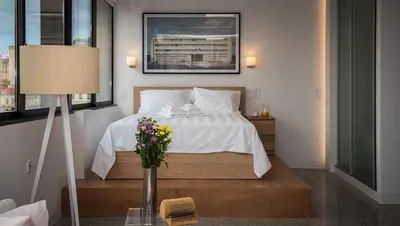 a bedroom with a bed and a table with a vase of flowers at Majestic City Hall in Athens