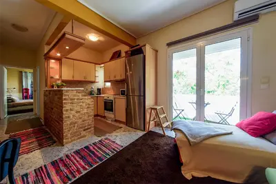 a kitchen with a bed and a large window at warm cozy & quiet in Athens