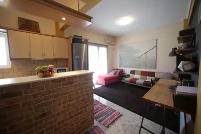 a kitchen and living room with a brick wall at warm cozy & quiet in Athens