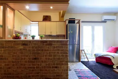 a kitchen with a brick wall and a refrigerator at warm cozy & quiet in Athens
