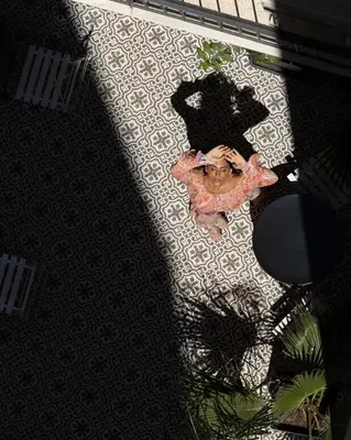 an overhead view of a woman laying on a floor at PAME House in Athens