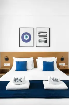 a bedroom with a large bed with blue and white pillows at PAME House in Athens