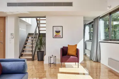 a living room with a purple chair and stairs at MONO Lofts in Athens