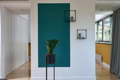 a hallway with a green wall and a potted plant at MONO Lofts in Athens