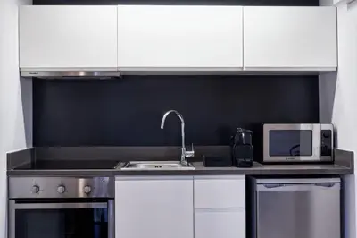 a kitchen with white cabinets and a sink and a microwave at MONO Lofts in Athens