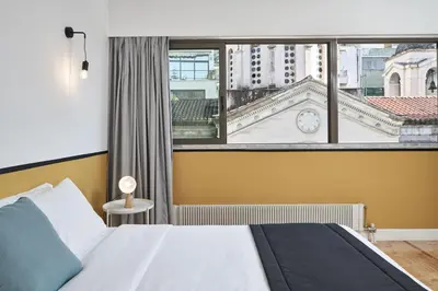 a bedroom with a bed and a large window at MONO Lofts in Athens
