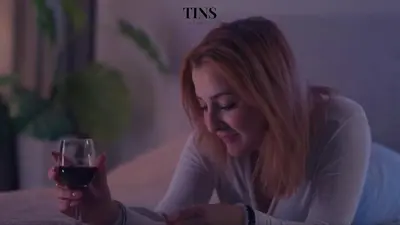 a woman sitting on a couch holding a glass of wine at Tins Athens in Athens
