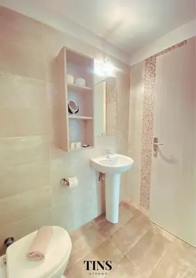 a bathroom with a white sink and a toilet at Tins Athens in Athens