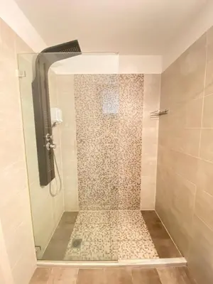 a shower with a glass door in a bathroom at Tins Athens in Athens