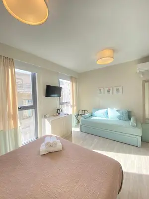 a bedroom with a bed with two towels on it at Tins Athens in Athens