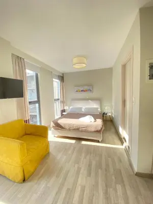 a bedroom with a bed and a yellow chair at Tins Athens in Athens