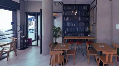 a restaurant with wooden tables and chairs in a room at Tins Athens in Athens