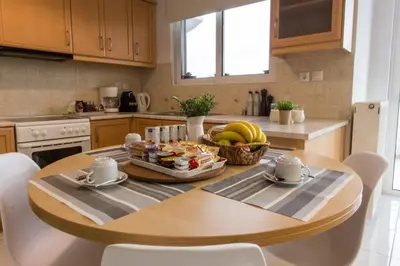 a kitchen with a table with a tray of food on it at Nathaniel Athens Airport in Spáta
