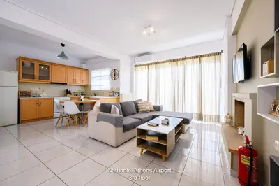 a living room with a couch and a table at Nathaniel Athens Airport in Spáta