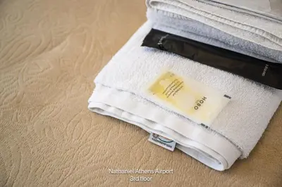 a white towel with a bar of soap on the floor at Nathaniel Athens Airport in Spáta