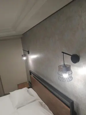 a bedroom with a bed and a lamp on the wall at Elaėa Boutique Apartments in Piraeus