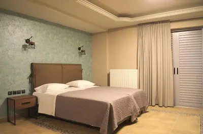 a bedroom with a large bed and a window at Elaėa Boutique Apartments in Piraeus