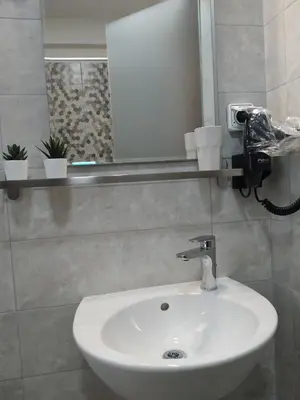 a bathroom with a white sink and a mirror at Elaėa Boutique Apartments in Piraeus