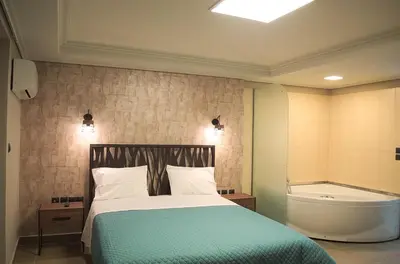 a bedroom with a bed and a bath tub at Elaėa Boutique Apartments in Piraeus