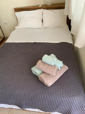 a bed with three towels sitting on top of it at Acropolis View in Athens