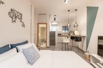 a bedroom with a white bed and a kitchen at Ports Crossroad A in Piraeus