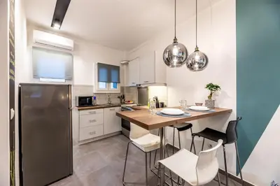 a kitchen with a table and chairs and a refrigerator at Ports Crossroad A in Piraeus