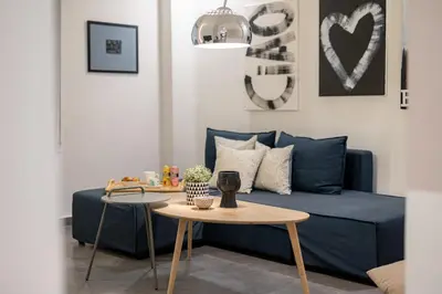 a living room with a blue couch and a table at Ports Crossroad C in Piraeus