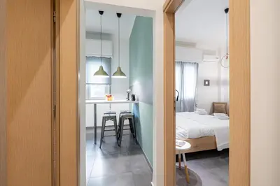 a room with a bed and a kitchen with a table at Ports Crossroad C in Piraeus