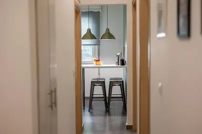 a kitchen with a table and stools in a room at Ports Crossroad C in Piraeus