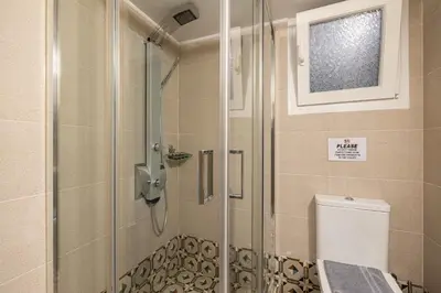 a shower in a bathroom with a toilet and a window at Ports Crossroad C in Piraeus