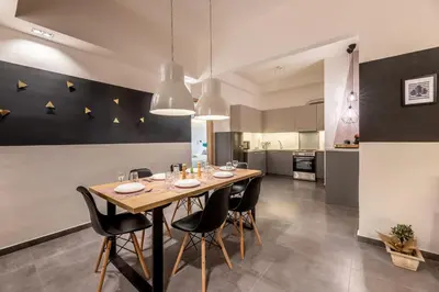 a dining room with a wooden table and black chairs at Ports Crossroad D in Piraeus