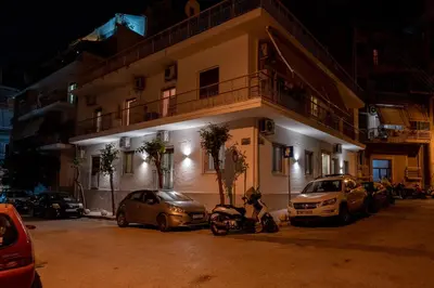 a building with cars parked in front of it at night at Ports Crossroad D in Piraeus