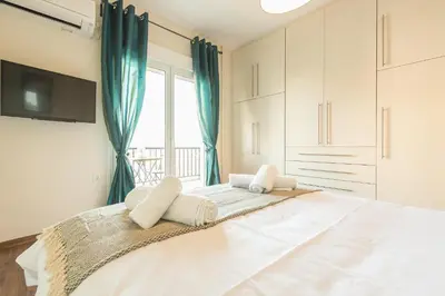 a bedroom with a large bed with a window at Incredible Acropolis View Flat! in Athens
