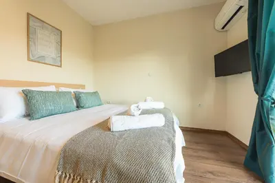 a bedroom with a large white bed with blue pillows at Incredible Acropolis View Flat! in Athens