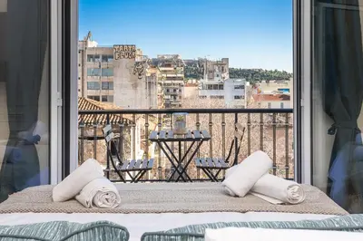 a bedroom with a balcony with a view of a city at Incredible Acropolis View Flat! in Athens