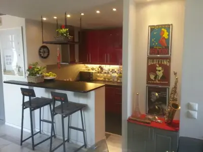a kitchen with a counter and two stools at a bar at Varkiza Seaside Penthouse with Private Roof Deck in Vari