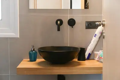 a black bowl on a wooden counter in a bathroom at Triple A - Acropolis View in Psiri Athens - FREE Parking! in Athens